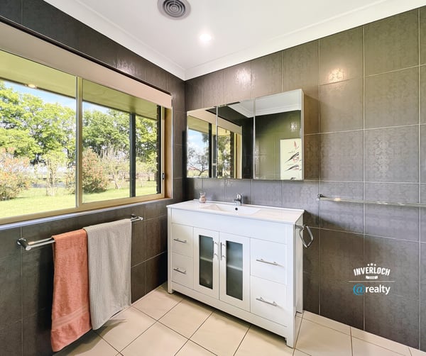 Bright and airy bathroom featuring modern fixtures, ample natural light, and scenic garden views.