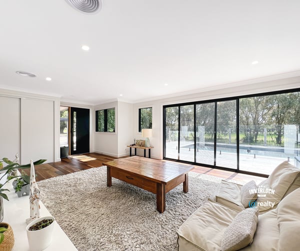 Spacious living area features large windows, abundant natural light, and direct access to outdoor spaces.