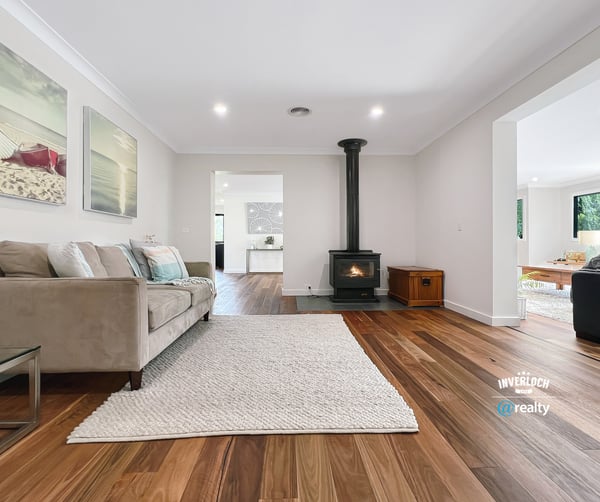 Spacious living area featuring natural light, modern decor, and a cozy fireplace, perfect for gatherings.