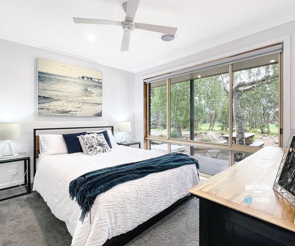 Bright bedroom with large windows offering scenic views and modern finishes for comfortable living.