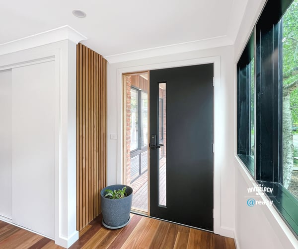 Contemporary entryway featuring a sleek front door and natural light enhancing the warm wooden floors.
