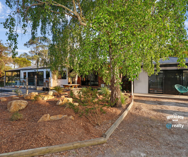 Contemporary home surrounded by lush landscaping, featuring spacious outdoor areas and modern design elements.
