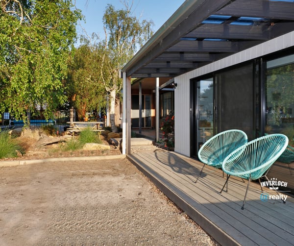 Discover this contemporary home featuring inviting outdoor seating and a spacious yard, perfect for entertaining.