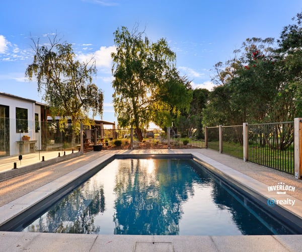 Discover this inviting outdoor space featuring a refreshing pool, surrounded by lush greenery and modern amenities.