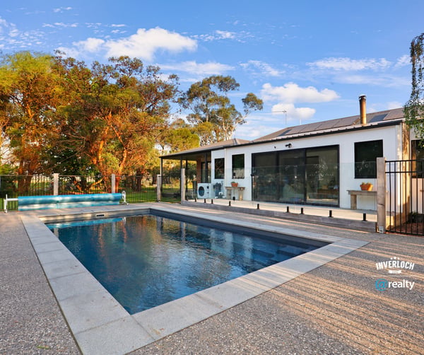 Contemporary home featuring an inviting pool area, surrounded by lush landscaping and ample outdoor space for relaxation.