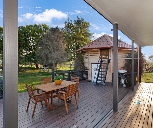 Spacious outdoor deck with direct access to lush greenery, ideal for entertaining and relaxation.