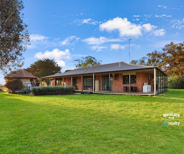 Spacious home set on expansive grounds, featuring large windows and a seamless indoor-outdoor living experience.
